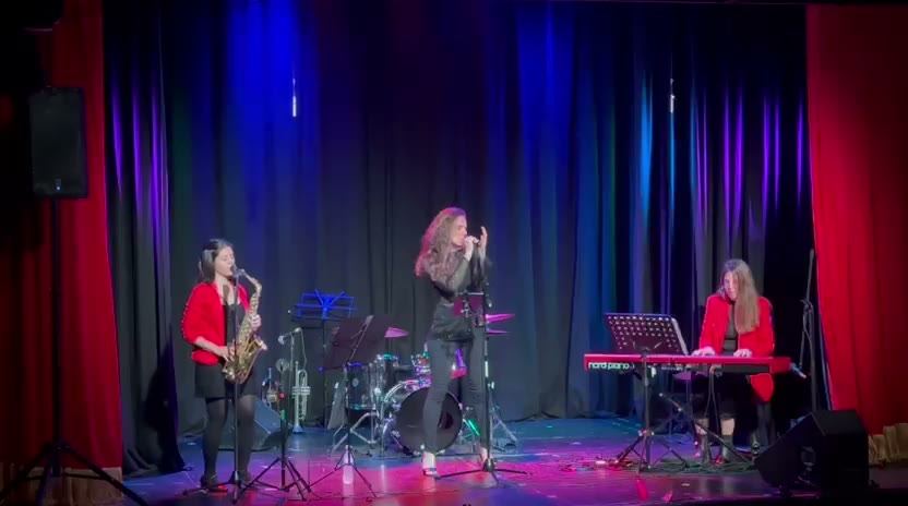Grupo NINFA actuando bajo luces azules y violetas