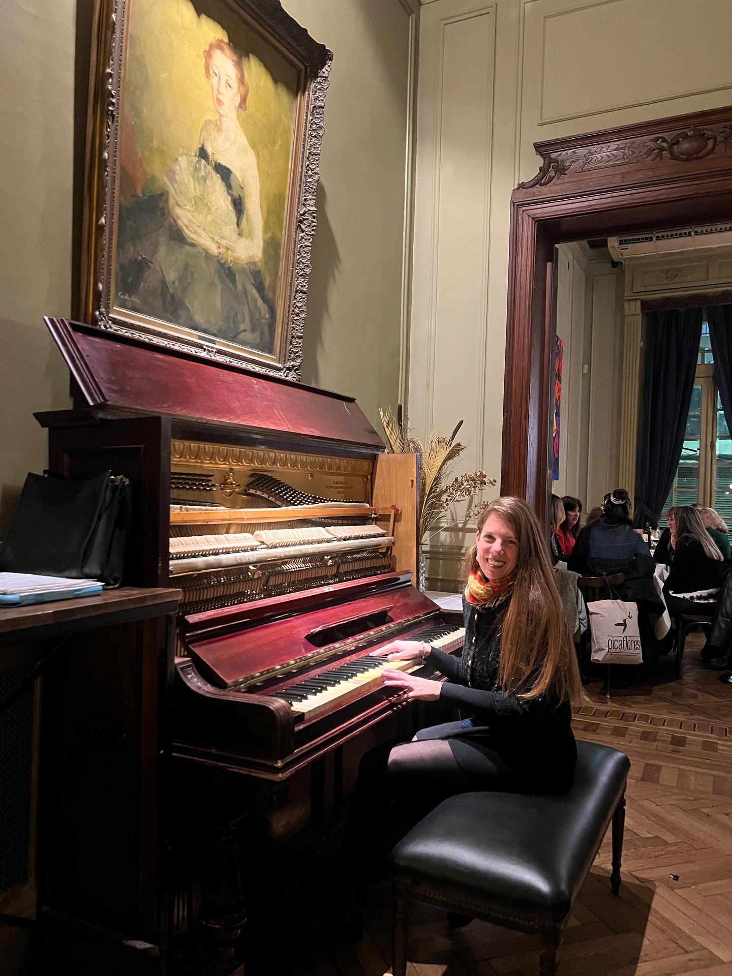 Pilar sonríe frente a un piano vertical histórico